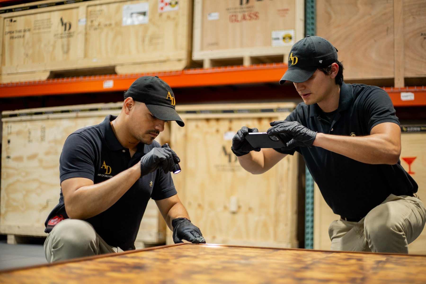 Specialists condition-reporting and photographing a table in the warehouse