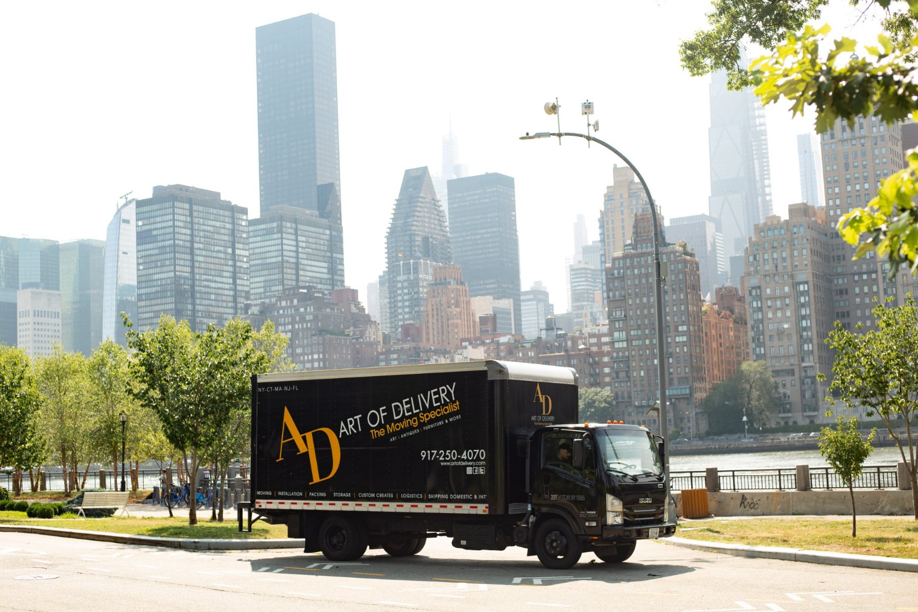 Art of Delivery branded truck against the New York City skyline