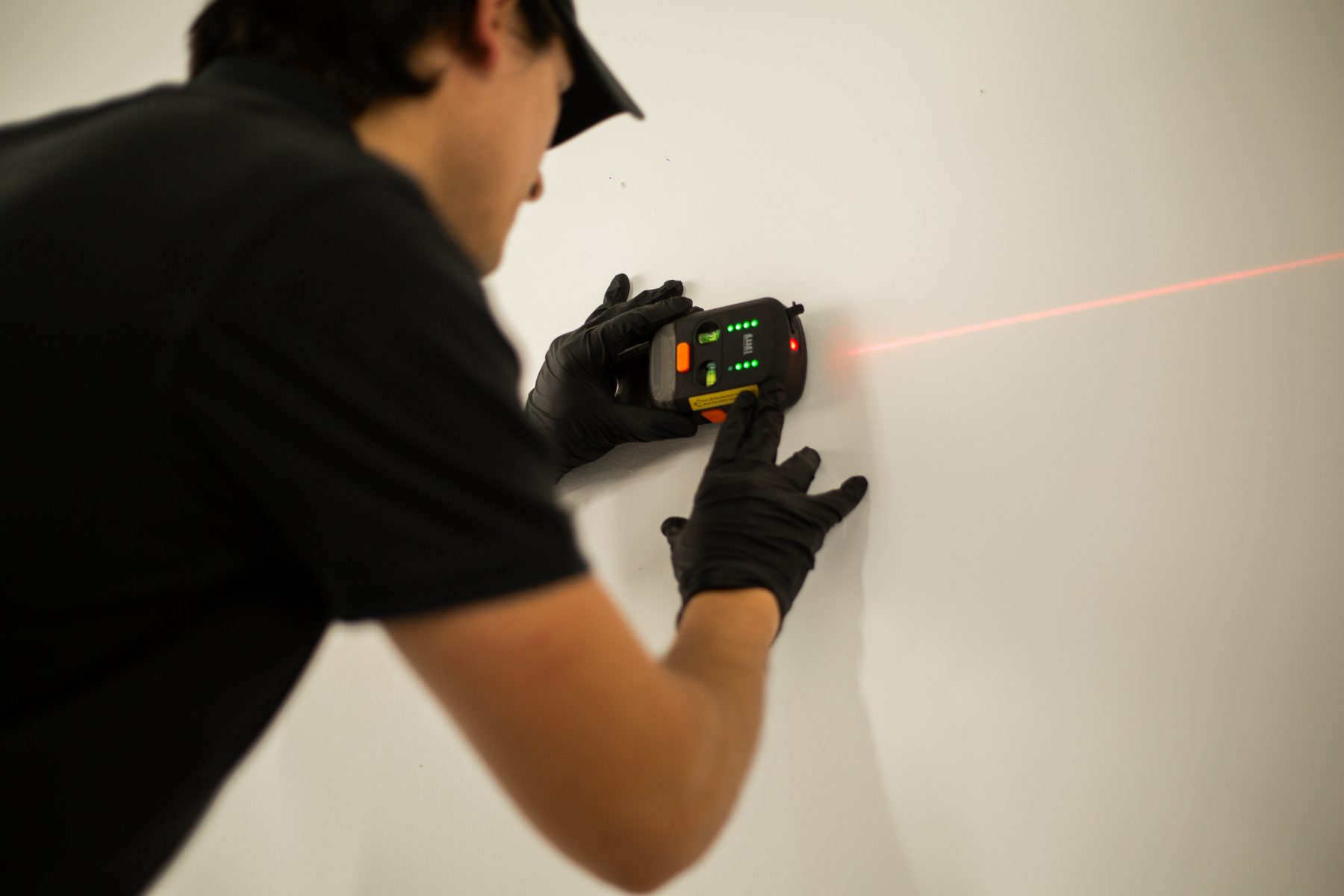 Specialist using a laser level for a wall installation