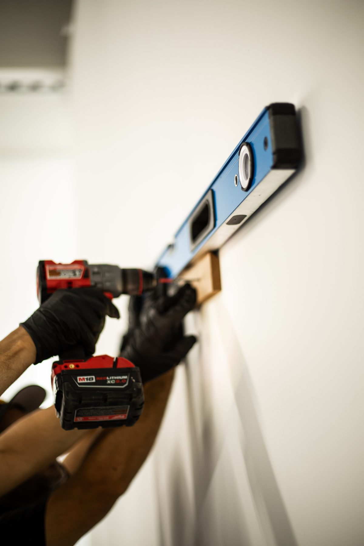 Specialist drilling a cleat to the wall during installation