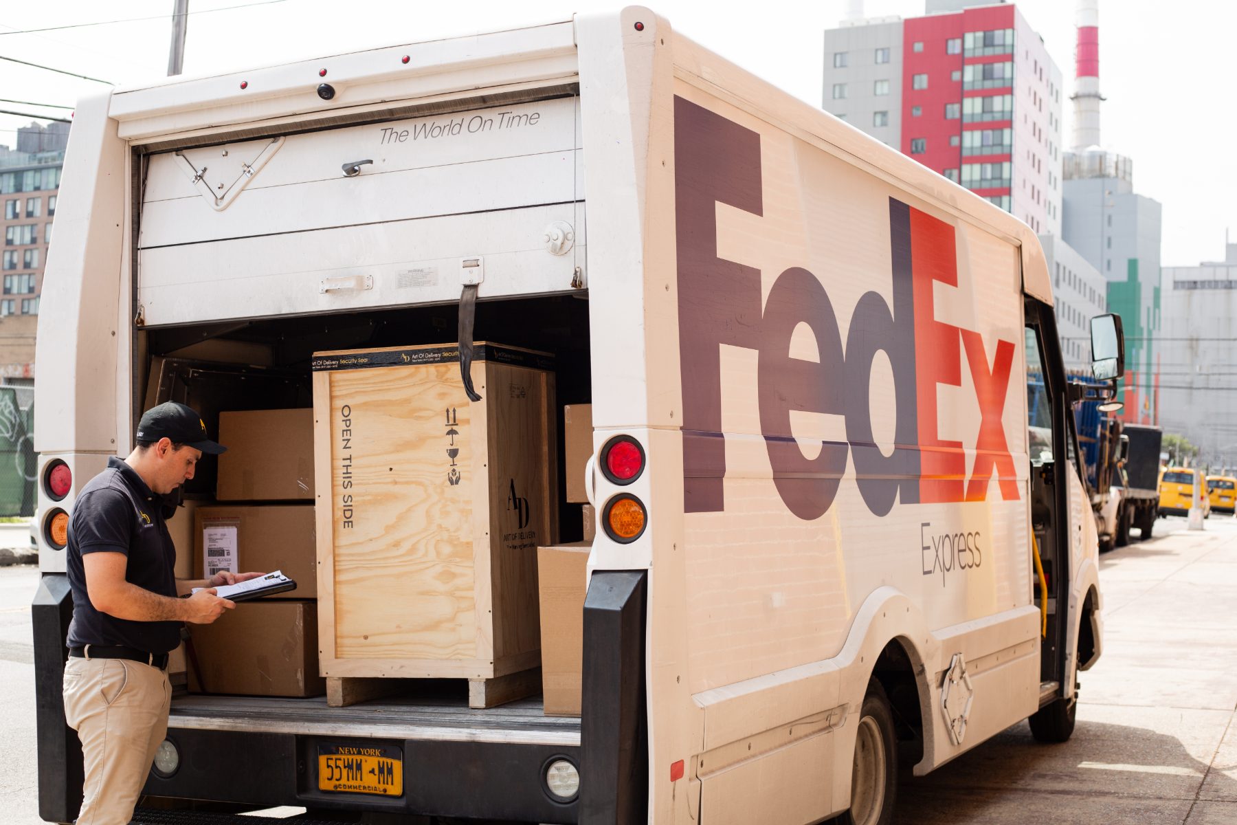 Specialist checking documentation at a loaded courier truck